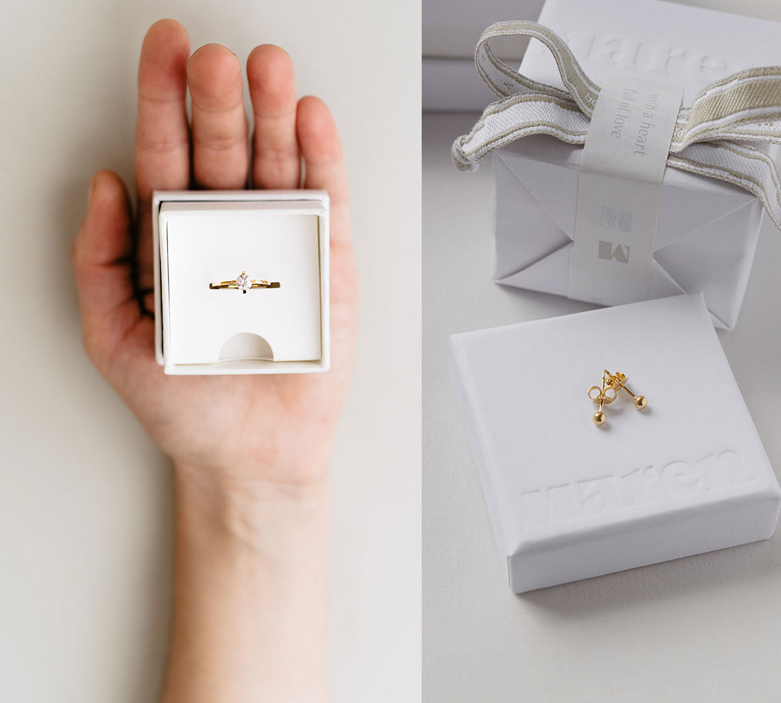 Hand hält ein Schmuckgeschenk und Schmuck als Geschenk auf Geschenkverpackung