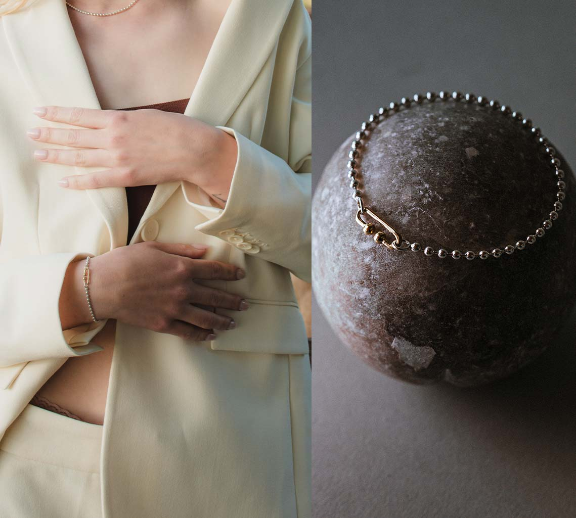 Frau mit Anzug und Silberarmband und Steinkugel mit Silberarmband
