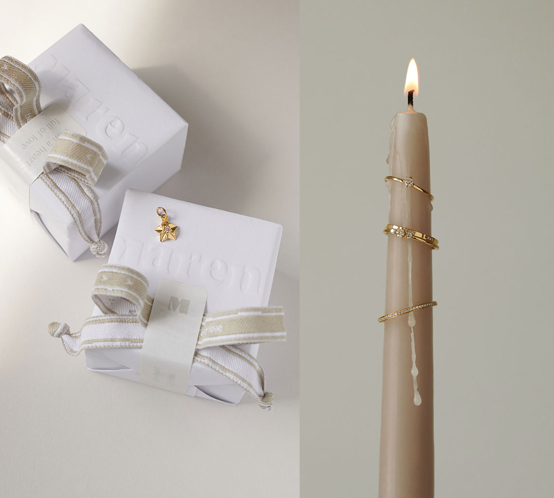 Weihnachtsgeschenke mit Stern Anhänger und Ringe auf Kerze