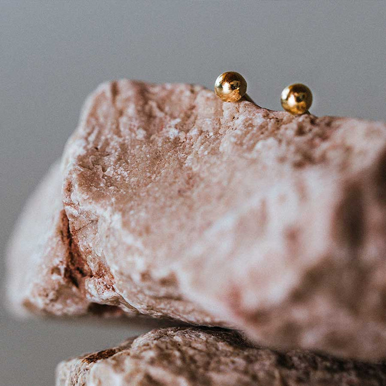 Gold Kugel Ohrring auf Stein fotografiert