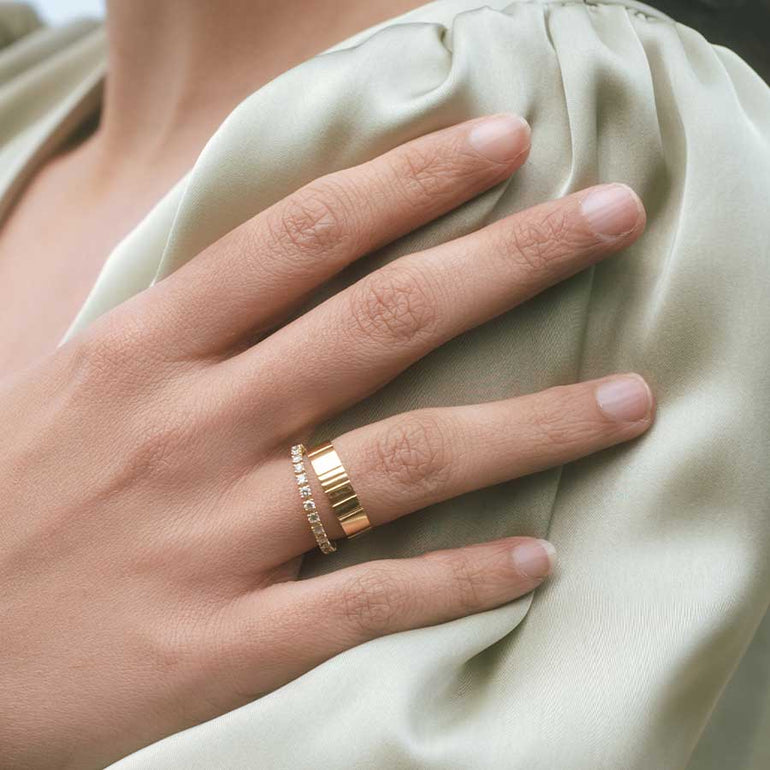 Nachhaltiger Verlobungsring und Ehering in Gold an Hand von Frau