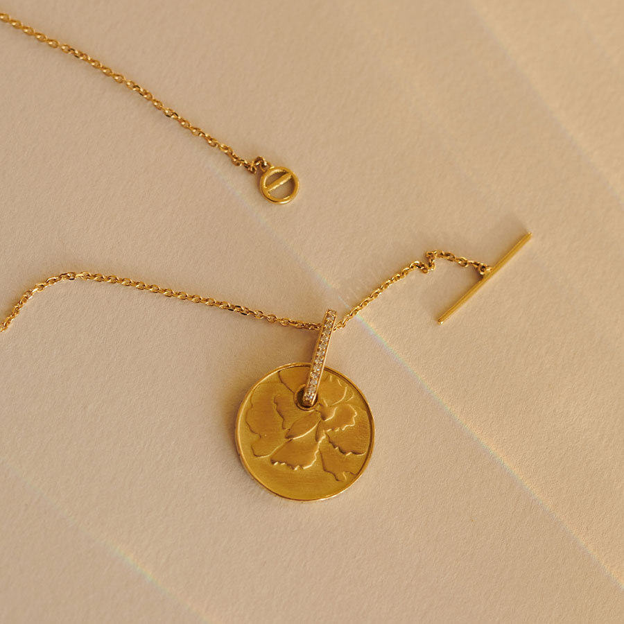 Münze mit Blumen Motiv an zarter Kette