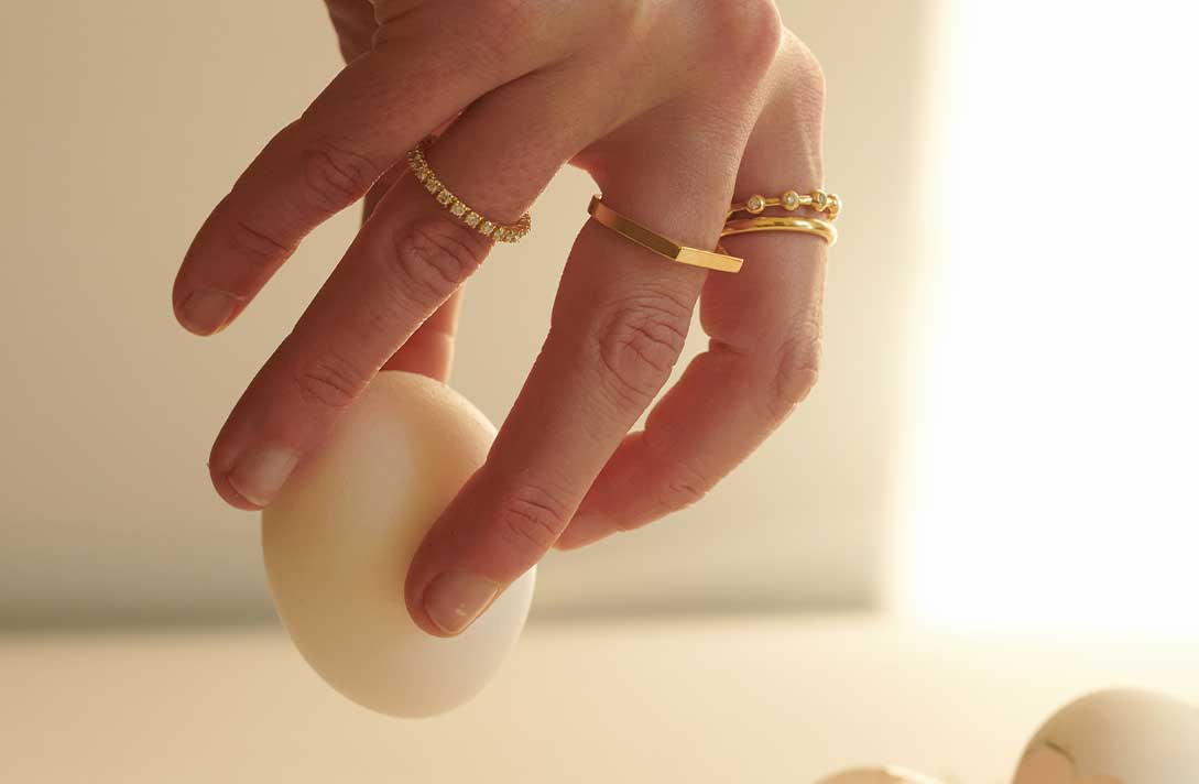 Hand mit schönen schlichten Designer Ringen in Gold
