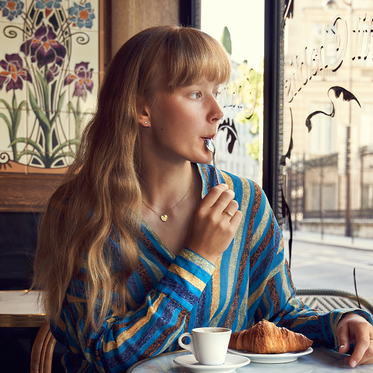 Frau im Cafe mit Herz Kette aus recyceltem Gold