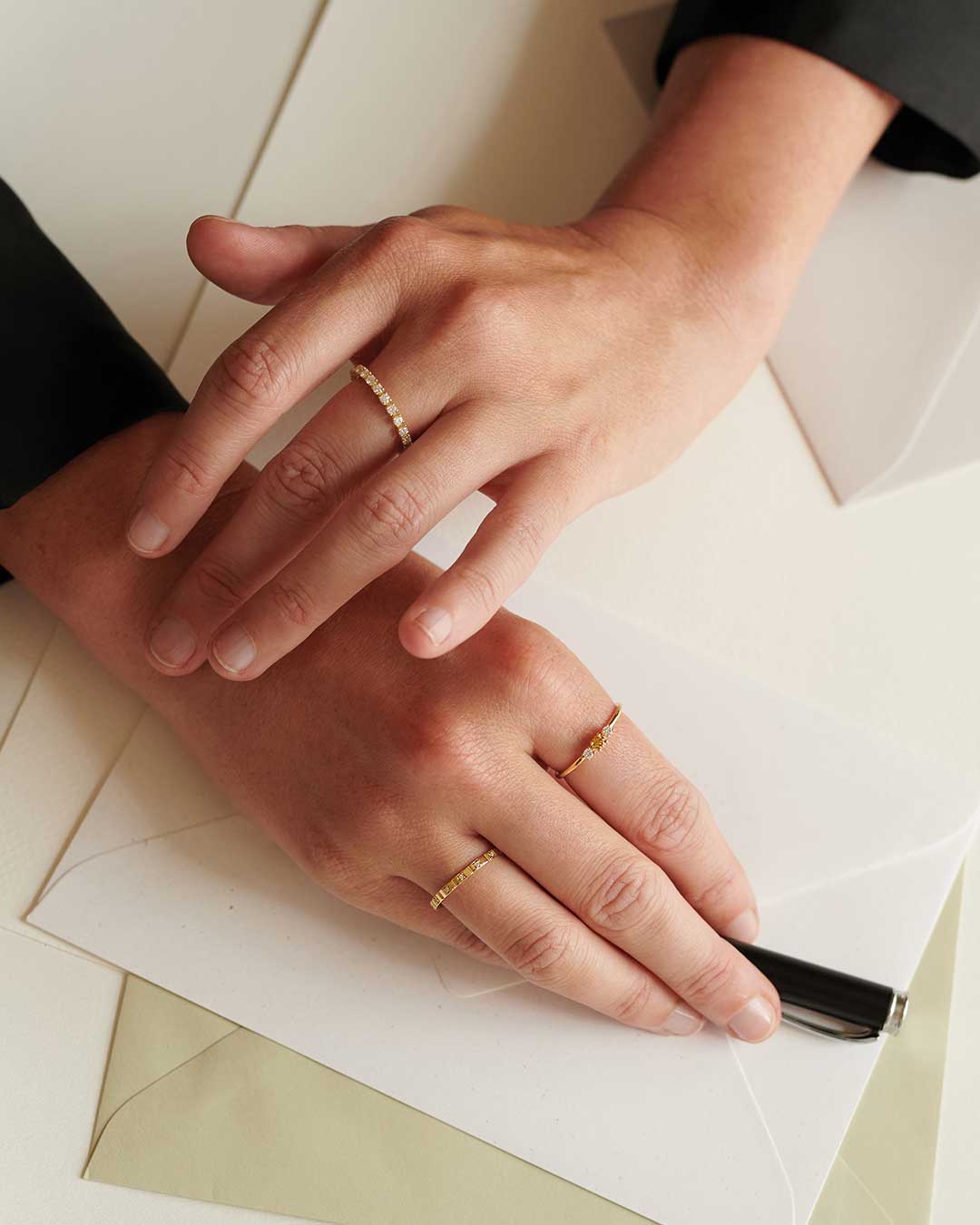 Frauenhände mit Ringen über einem Schreibtisch von oben fotografiert