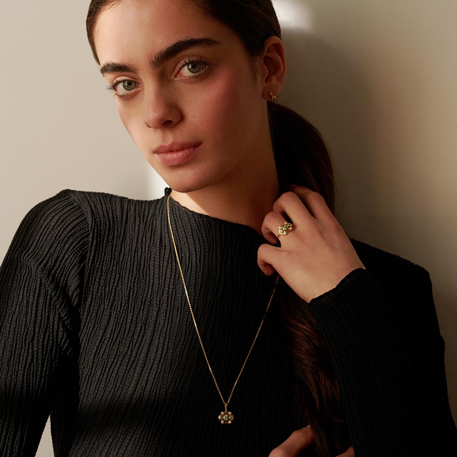 Frau with a long gold necklace and green lab-grown diamonds