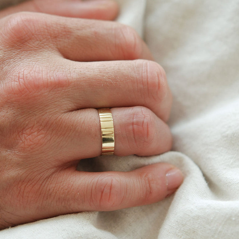 Männerhand mit breitem Goldehering