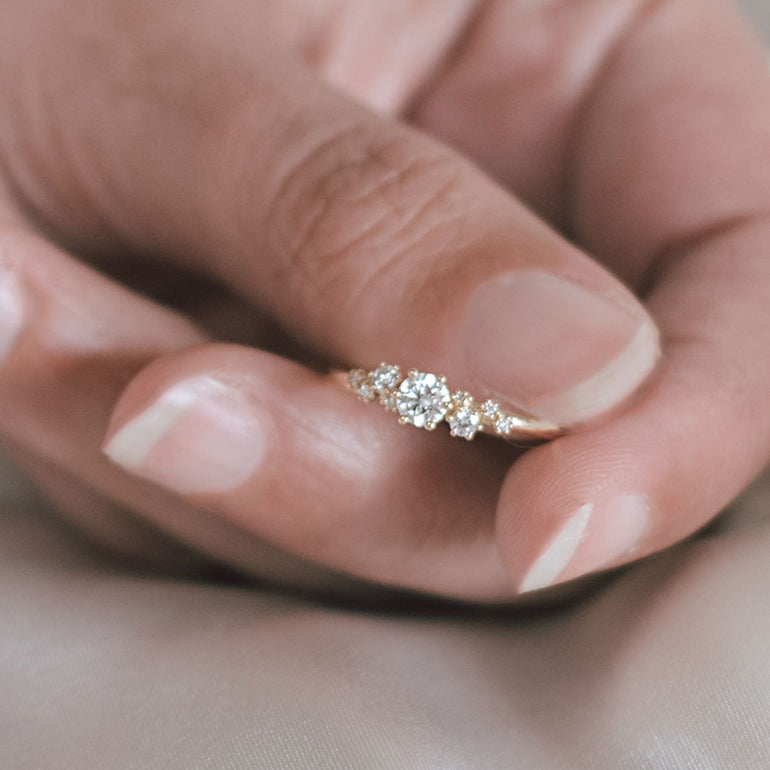 Frau zeigt Verlobugnring mit 9 Labor Diamanten elegant verstreut