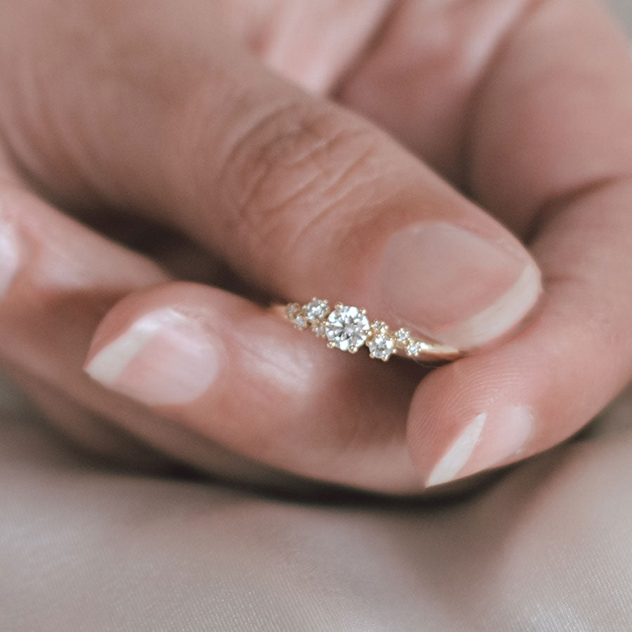 Frau zeigt Verlobugnring mit 9 Labor Diamanten elegant verstreut
