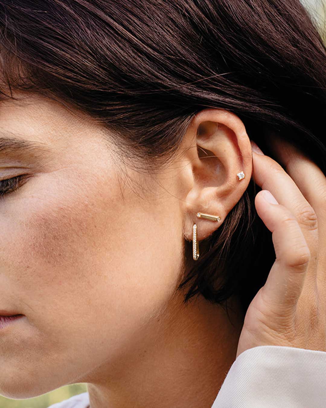 Model streicht sich ihr schwarzes Haar zurück, damit man die nachhaltigen Ohrstecker von Maren Jewellery sehen kann