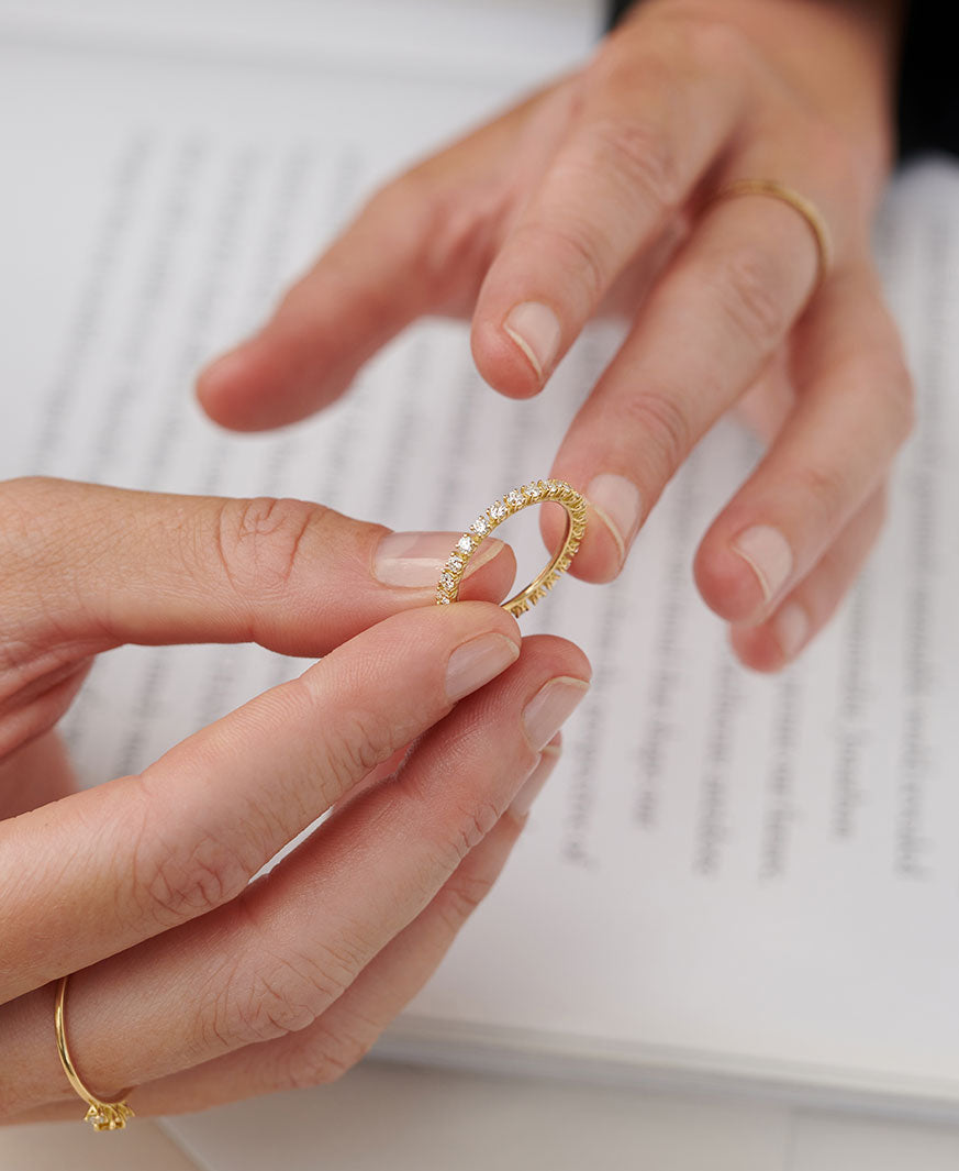 Hände halten einen Eternity Ring aus recyceltem Gold mit Labor Diamanten