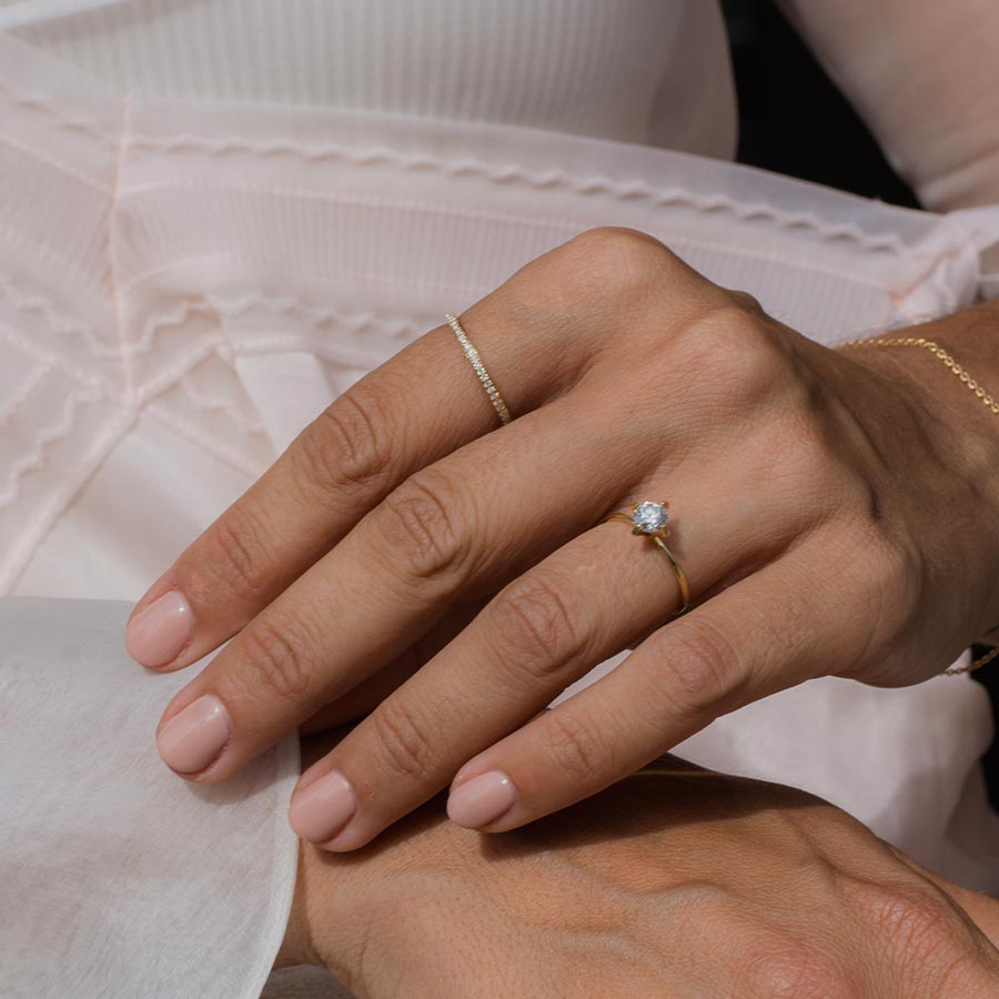 Ewigkeits Memoire- und Verlobungsring aus recyceltem Gold und mit Labordiamanten von Maren Jewellery an der Hand eines Models im weißen Kleid