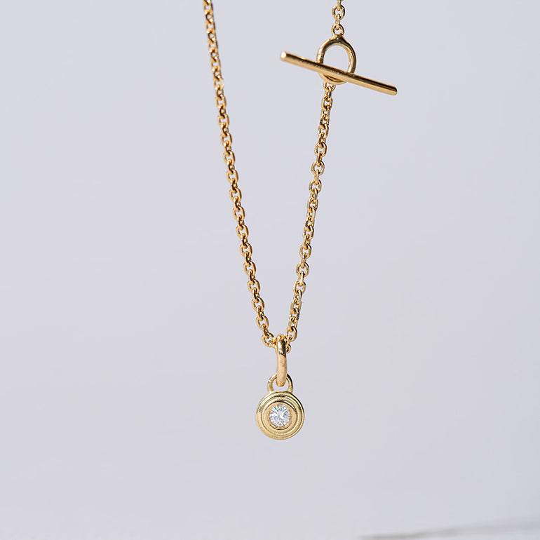 Nahaufnahme des feinen Drops of Memories Anhängers aus recyceltem Gold mit Labordiamant besetzt von Maren Jewellery an einer Kette hängend