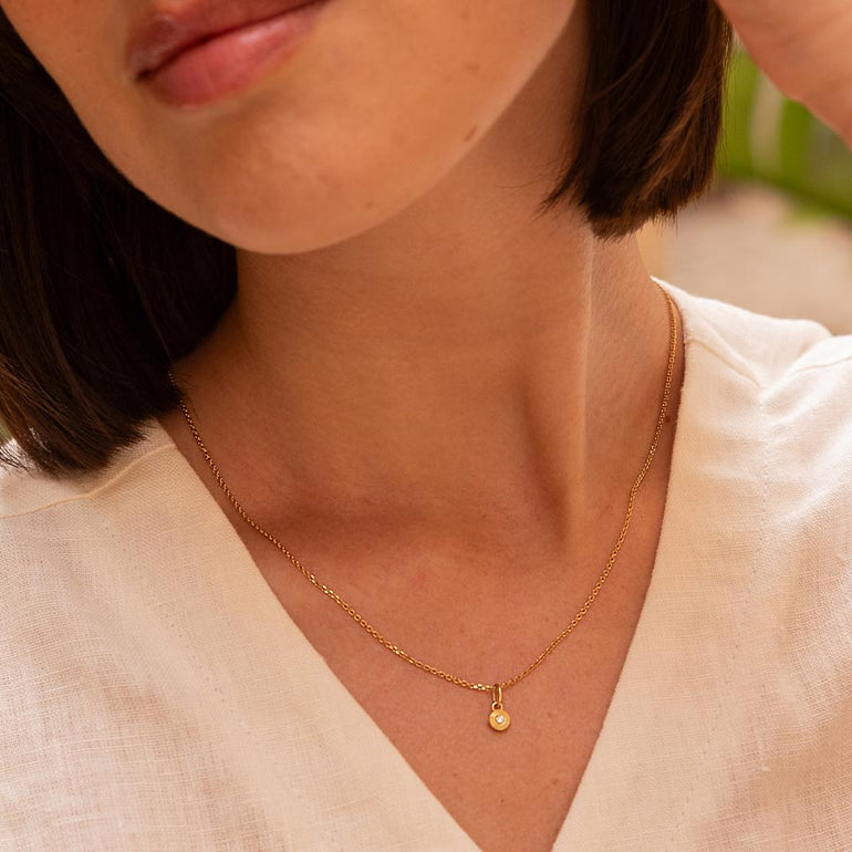 Feiner runder Anhänger aus recyceltem Gold und mit Labordiamant besetzt von Maren Jewellery an einer Kette um den Hals eines Models