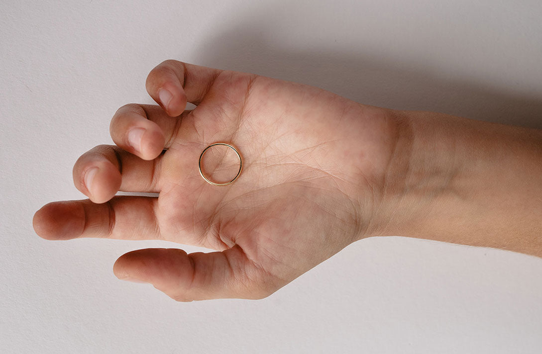 Ring aus recyceltem Gold liegt auf einer Hand