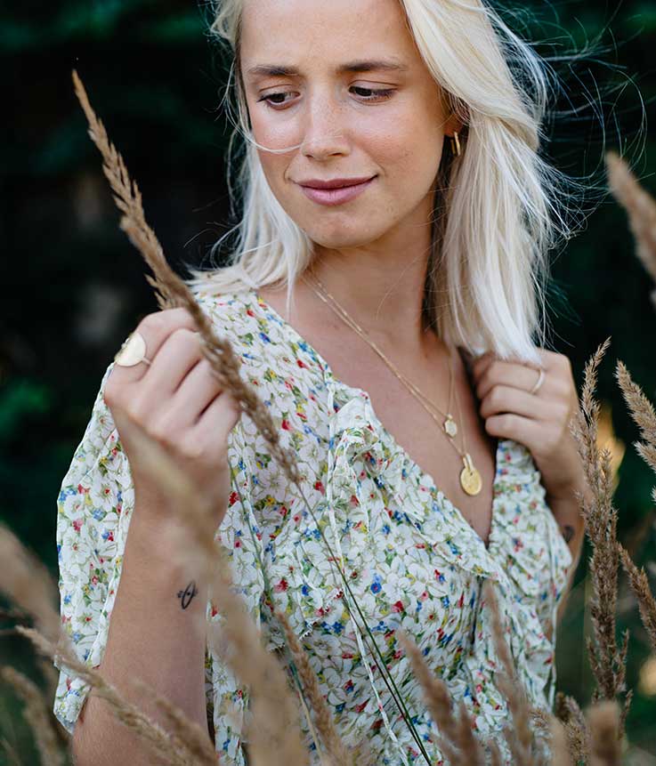 Junges Model in der Natur präsentiert den nachhaltigen Schmuck von Maren Jewellery