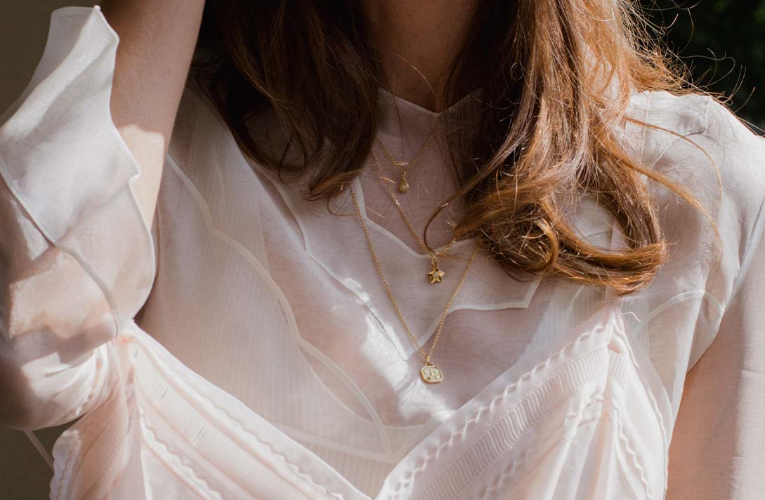 Inspiration zum Ketten Layering von Maren Jewellery Mit unterschiedlich langen Ketten und verschiedenen Anhängern aus recyceltem Gold