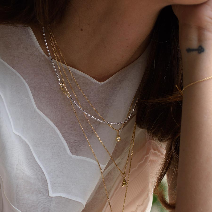 Bildausschnitt mit gelayerten Ketten von Maren Jewellery m Hals eines Models