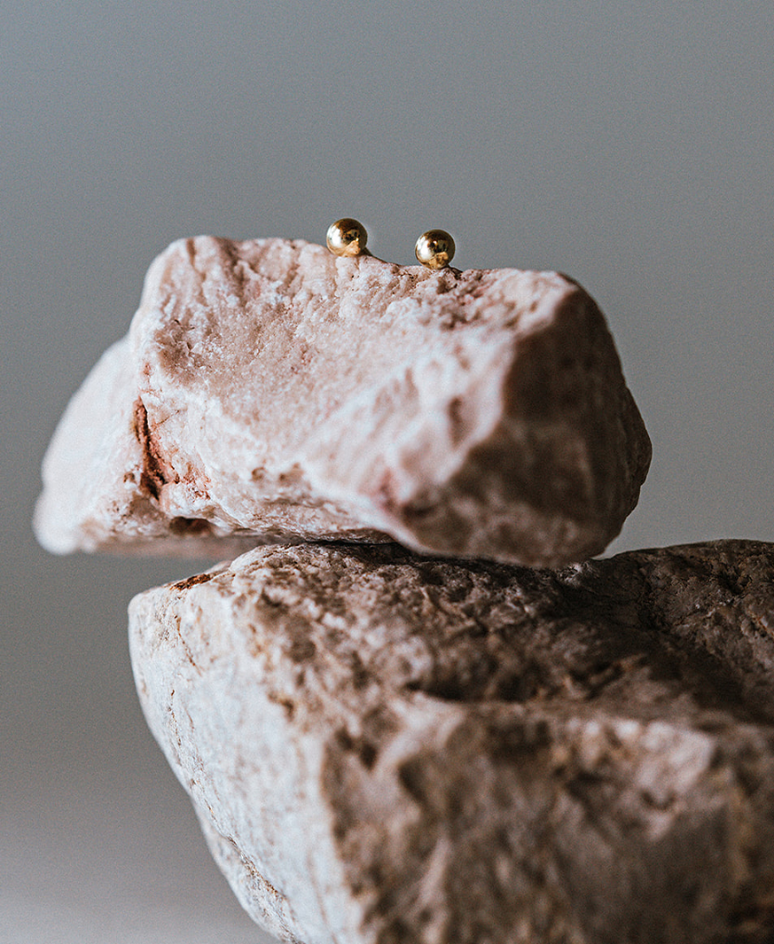 Kugel Ohrringe von Maren Jewellery auf Steinen liegend