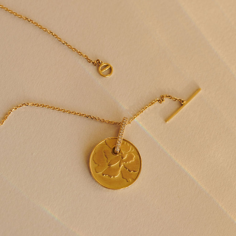 Münze mit Blumen Motiv an zarter Kette