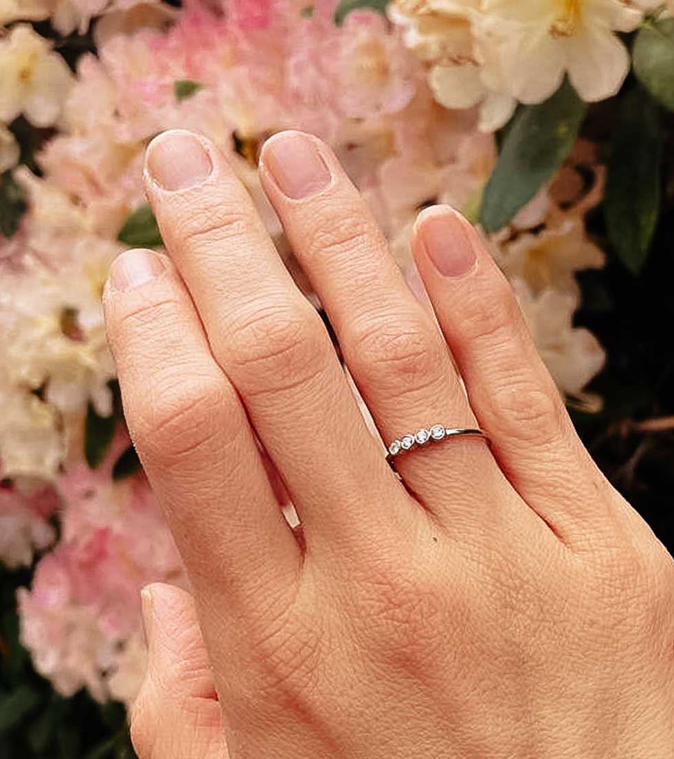 Hand mit schönem schlichten Ring mit 4 Steinen
