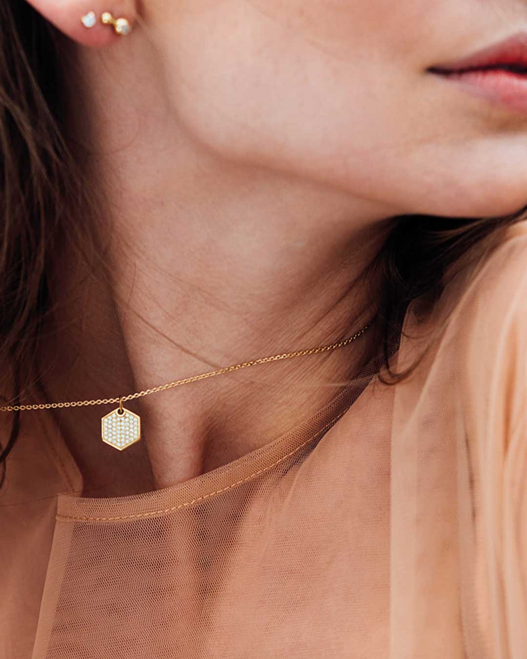 Nahaufnahme des Pave Anhängers aus recyceltem Gold mit Labordiamanten, von Maren Jewellery am Hals eines Models.