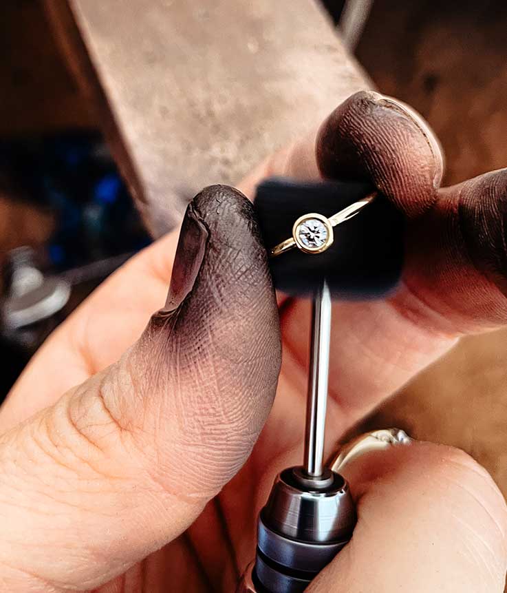 Detailaufnahme zeigt Polierarbeiten an einem handgefertigten Verlobungsring aus Recyclinggold von Maren Jewellery