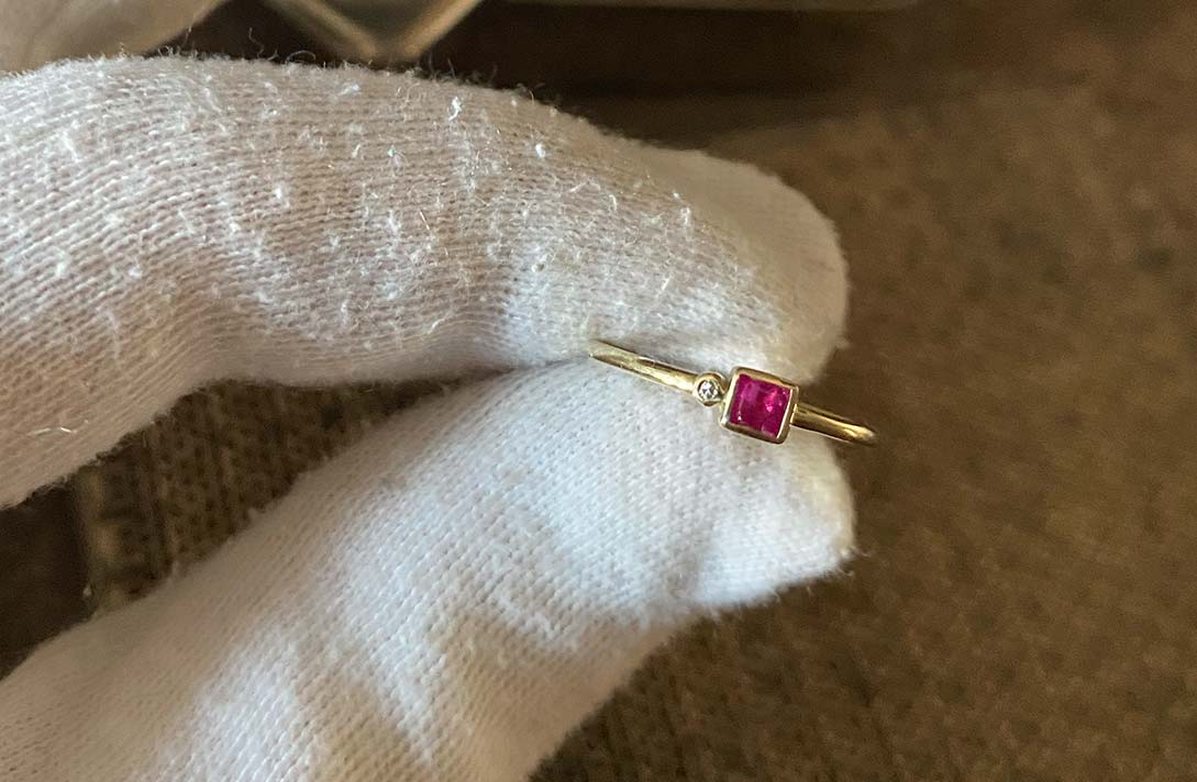 Hand in Samthandschuhen hält einen Ring in die Kamera, der achtsam in Manufaktur von  Maren Jewellery hergestellt wurde
