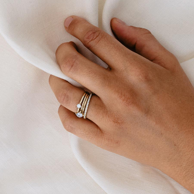Ringstack aus Ewigkeitsring und Solitair Ringen aus recyceltem Gold und Labordiamanten von Maren Jewellery an der Hand eines Models