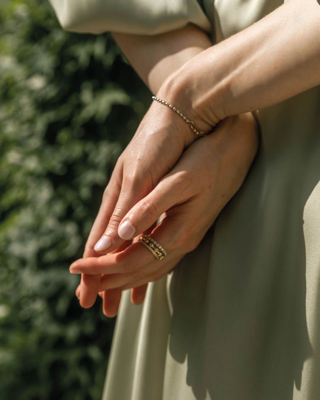 Detailaufnahme der Hand eines Models hinter ihrem Rücken mit gestackten Ringen von Maren Jewellery aus recyceltem Gold