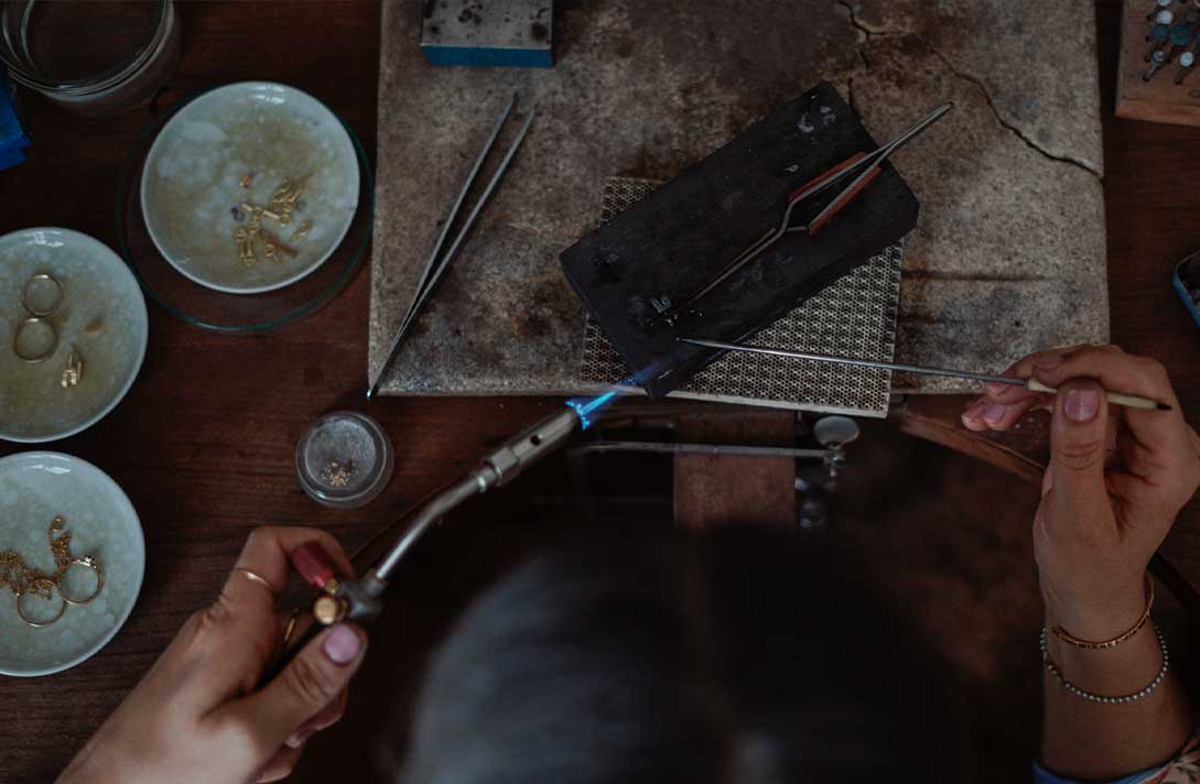 Aufnahme von oben zeigt Schmuckherstellung am Goldschmiedetisch im Maren Jewellery Studio am Chiemsee