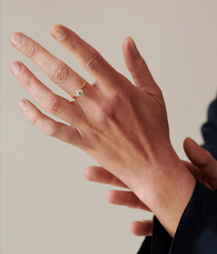 Solitärverlobungsring aus recyceltem Gold und Labordiamant an der Hand eines Models