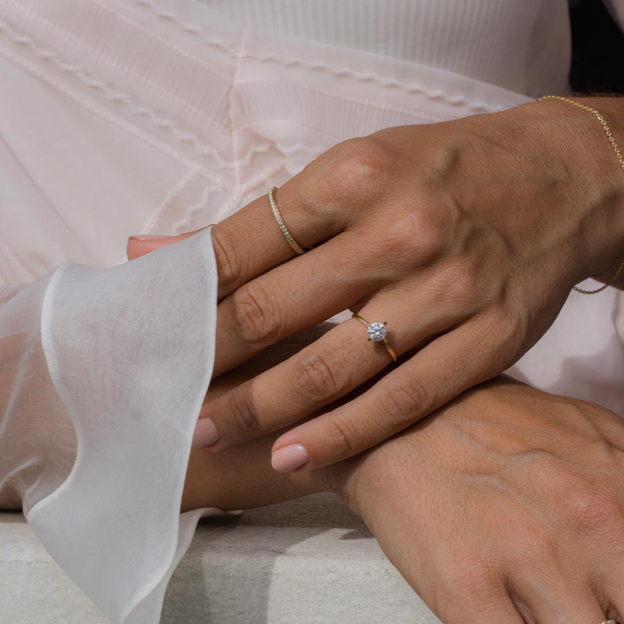Solitär Verlobungsring aus recyceltem Gold mit 0,5 Karat Labordiamant von  Maren Jewellery an der Hand eines Models im weißen Kleid