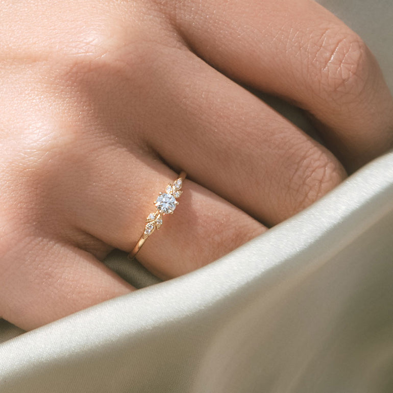 Verlobungsring mit Blättern und Solitär am Ringfinger getragen 
