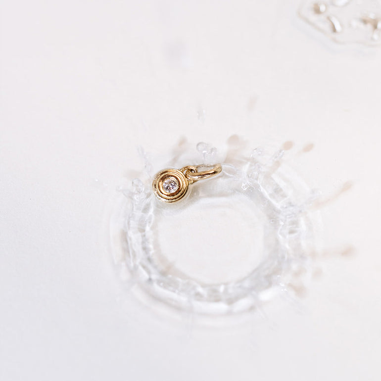 Vom Wasser inspirierter Designer Schmuckanhänger aus recyceltem Gold und mit Labordiamant besetzt von Maren Jewellery kunstvoll in spritzigem Wasser fotografiert