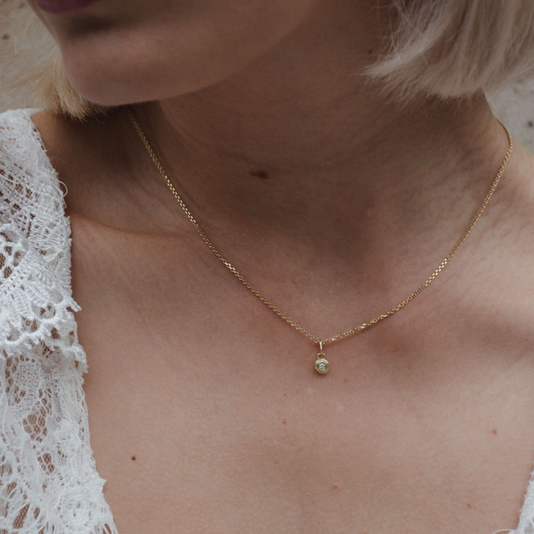 Zarte Kette mit feinem, zeitlosen Tropfenanhänger aus recyceltem Gold von Maren Jewellery am Hals eines Models