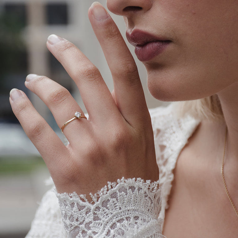Klassischer Solitaire Verlobungsring aus recyceltem Gold und Labordiamant von Maren Jewellery an der Hand eines Models im weißen Spitzenkleid